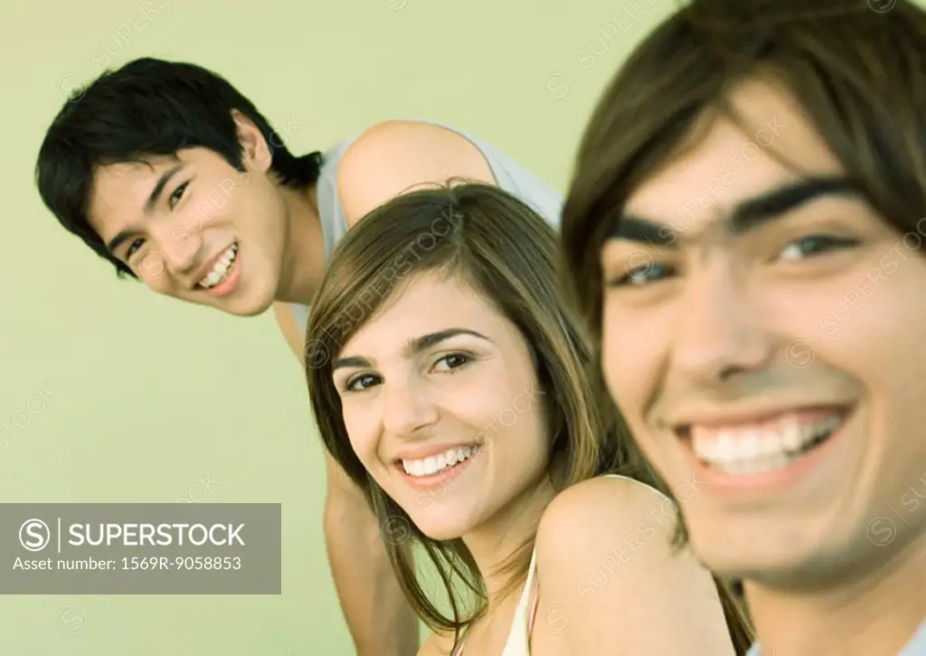 Three young adult friends smiling