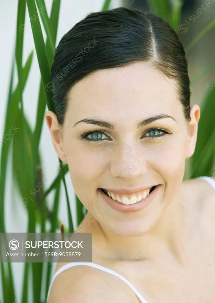 Young woman smiling, portrait, front view, close-up
