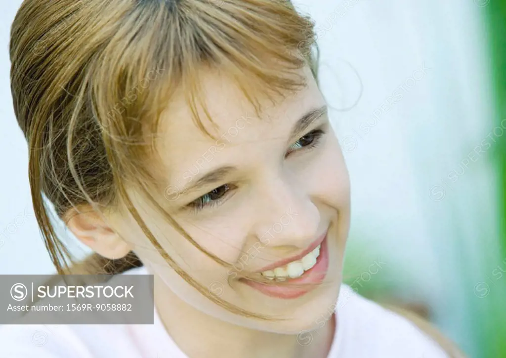 Girl smiling and looking away, portrait, close-up