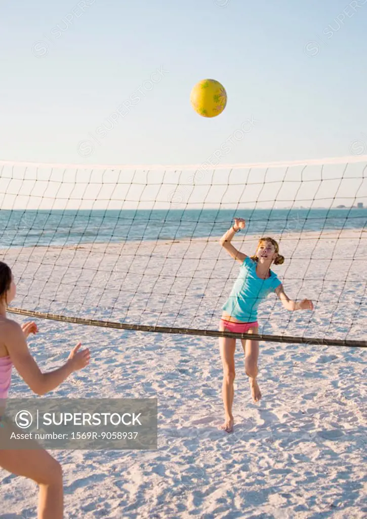 Two girls playing beach volleyball