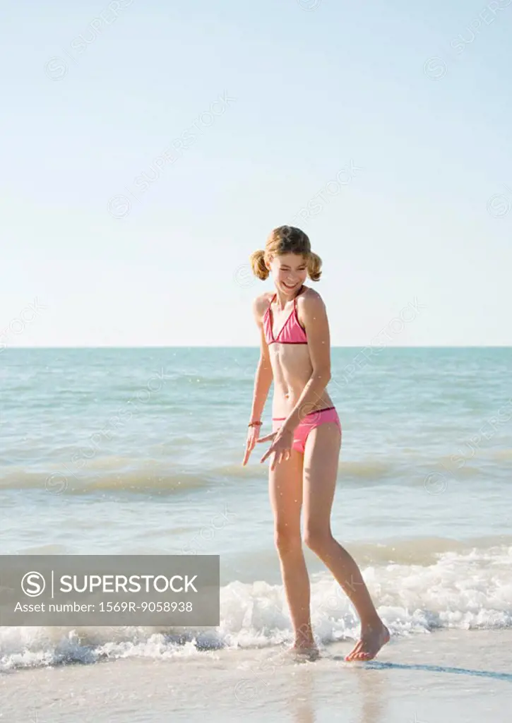 Girl standing in surf on beach