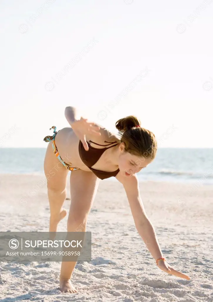 Girl starting cartwheel on beach