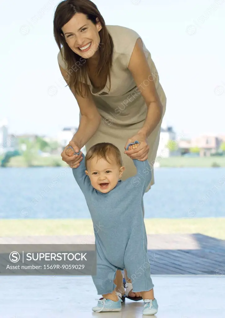Mother helping baby walk