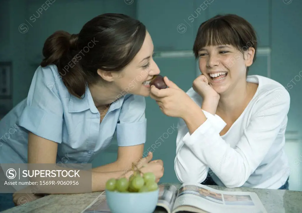 Mother eating fruit from daughter´s hand