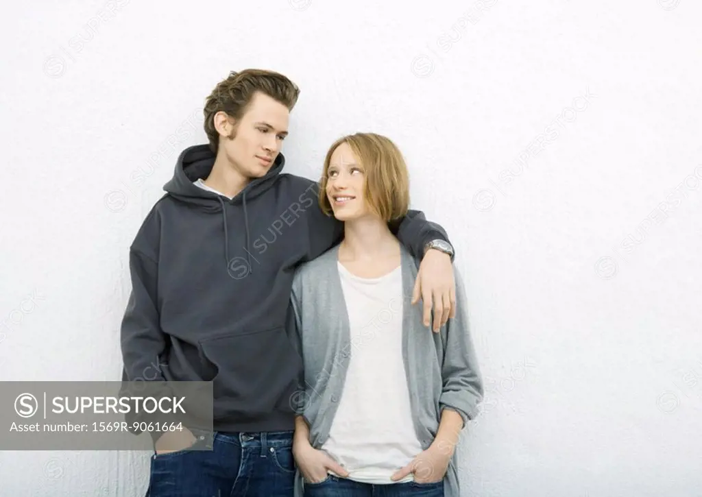 Young couple, man with arm around woman´s shoulder, woman looking up at him