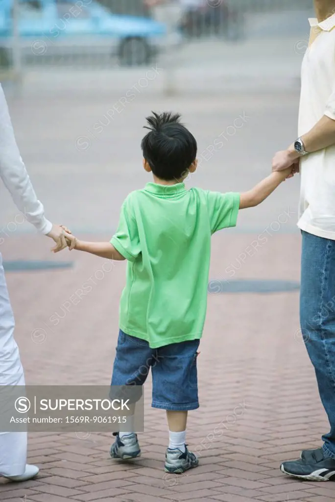 Boy holding parents´ hands