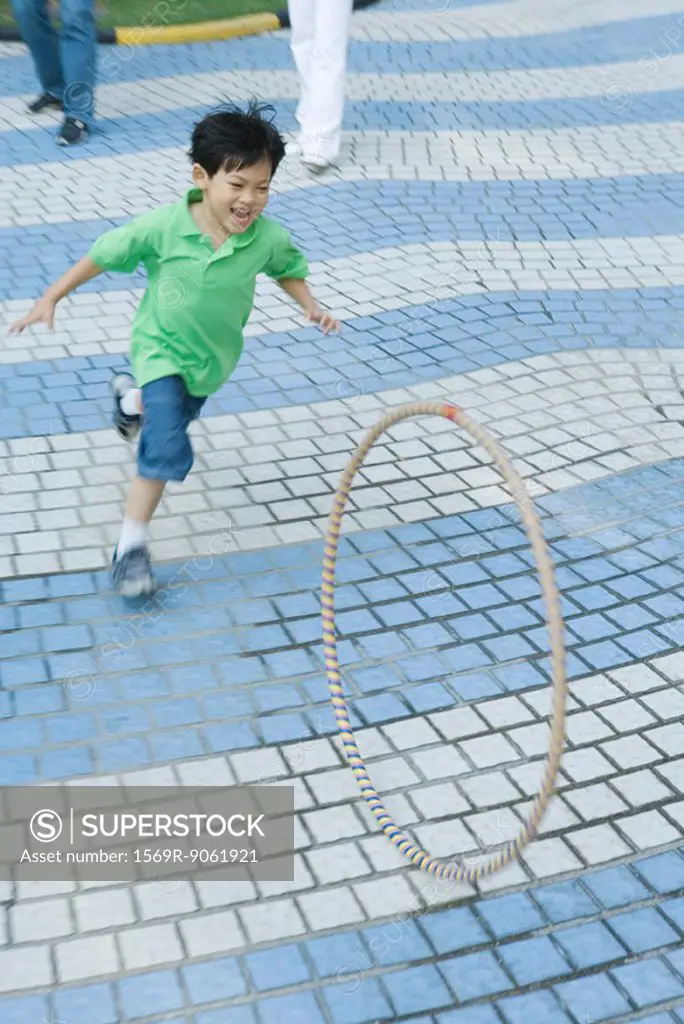 Boy chasing plastic hoop