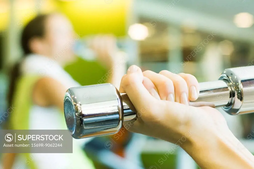 Woman´s hand holding dumbbell, close-up