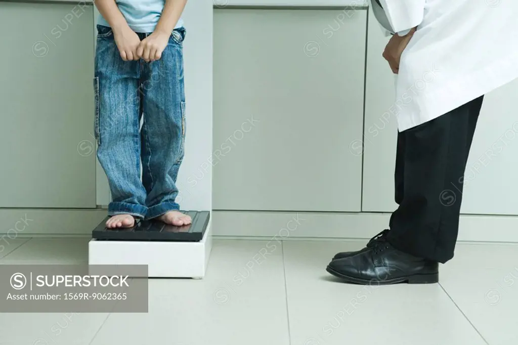 Boy standing on scale in doctor´s office, low section