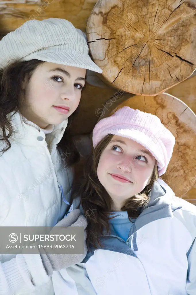 Two young friends smiling, wearing caps one looking at camera, portrait