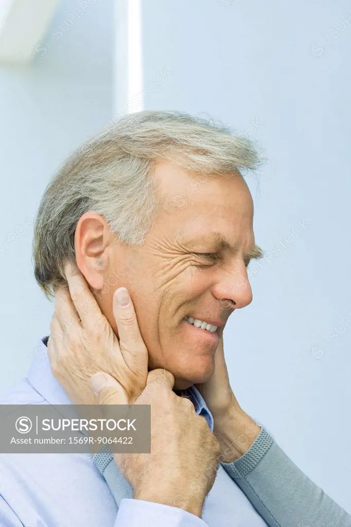 Mature man with wife´s hands on his face, cropped view