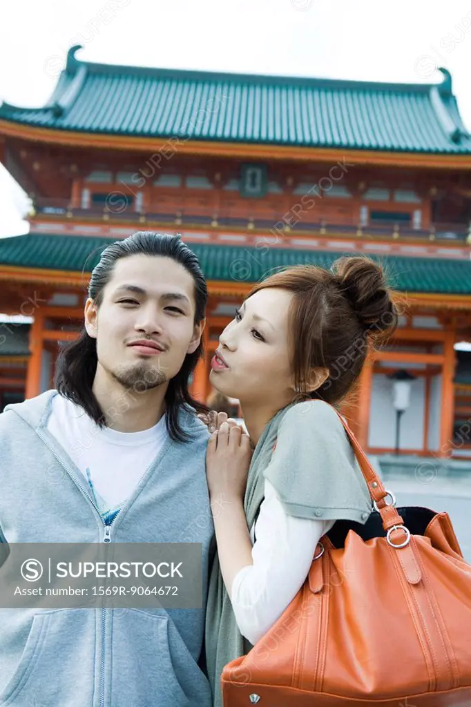Young couple standing in front of Japanese temple
