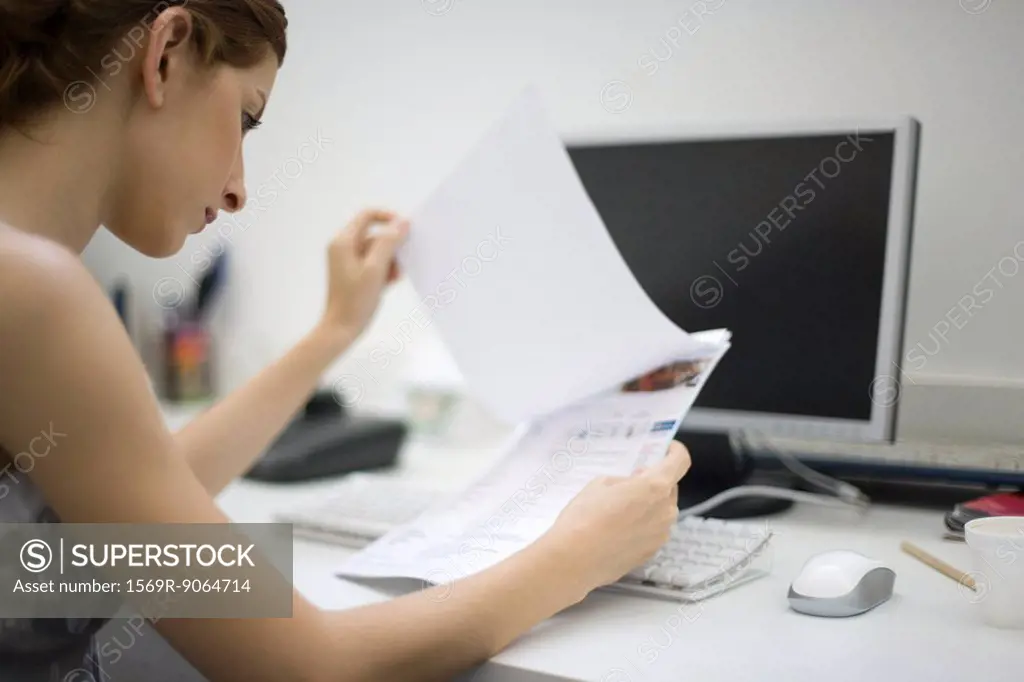 Woman reviewing document at desk