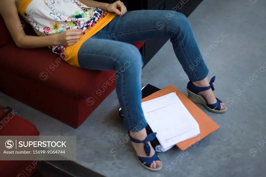 Woman sitting, files on the floor