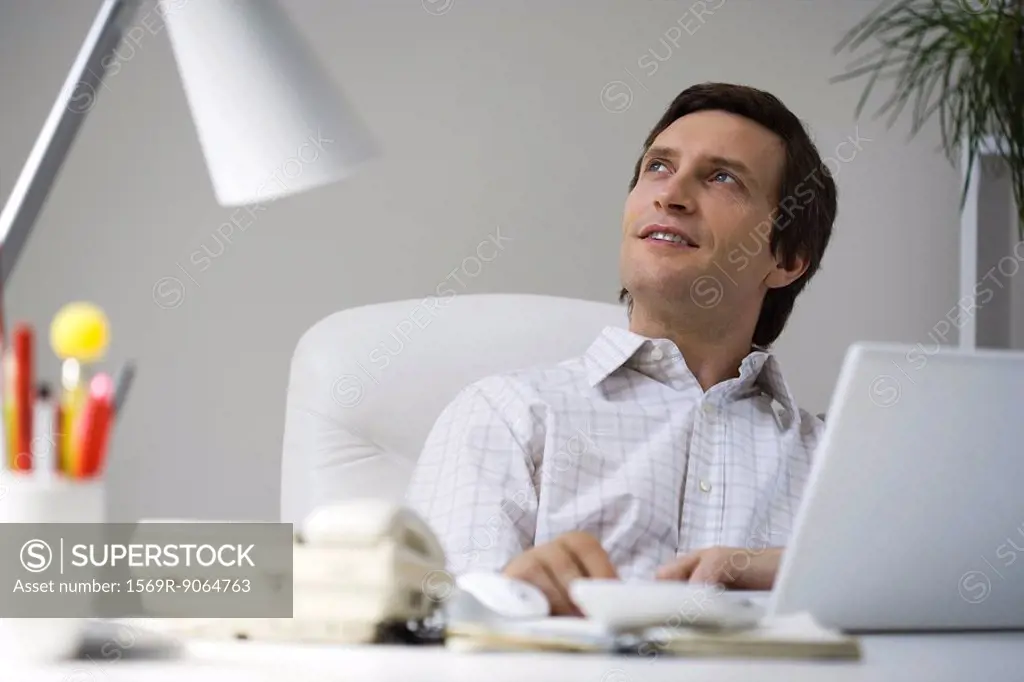Man sitting at desk, looking up