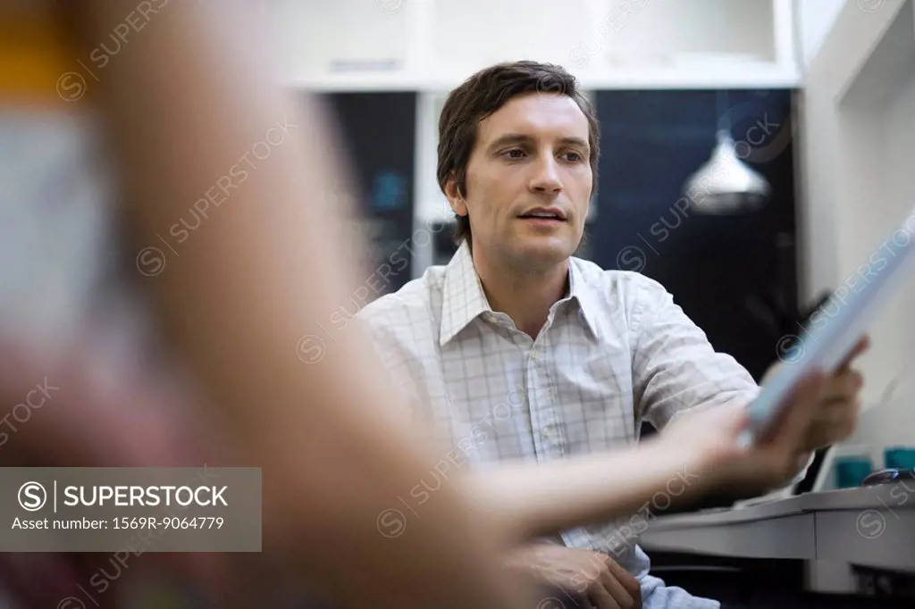 Man receiving document from colleague