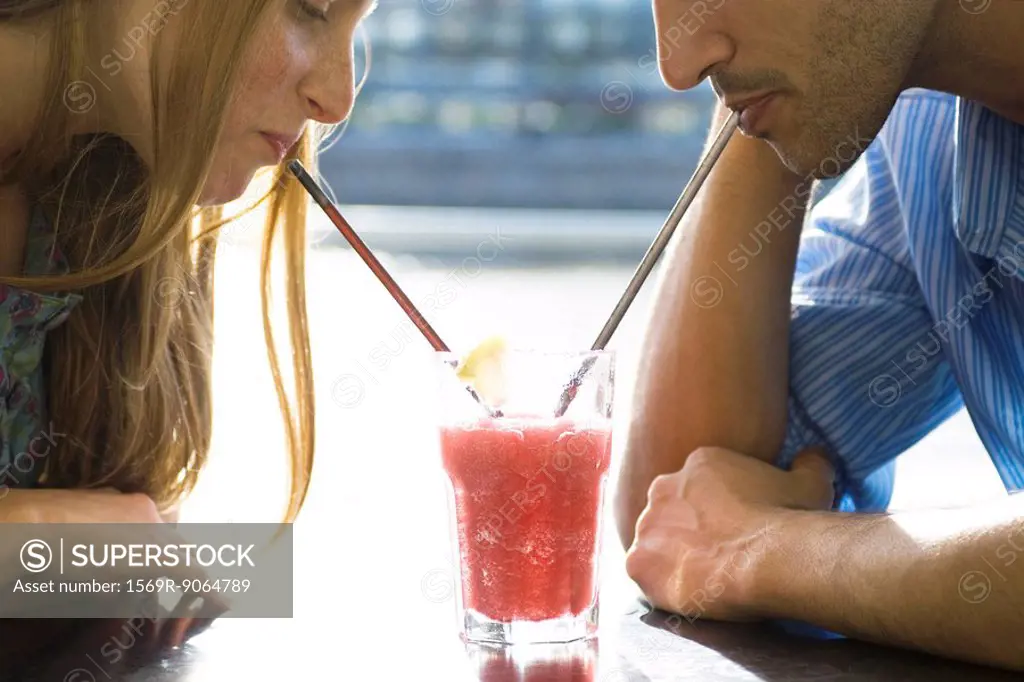 Couple sharing cool drink, cropped