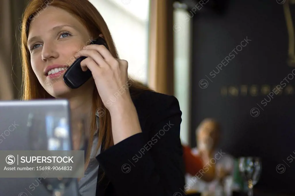 Woman using cell phone in restaurant