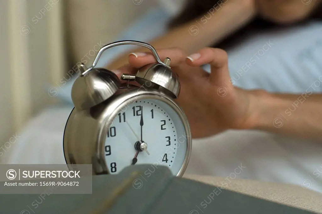 Woman´s hand silencing alarm clock
