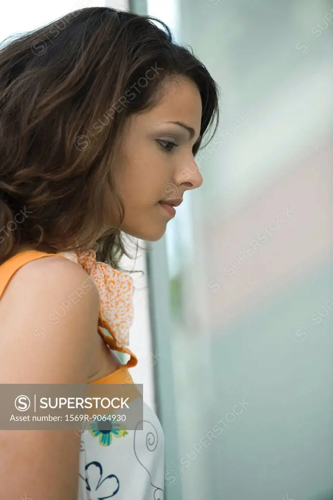 Young woman looking in window, profile