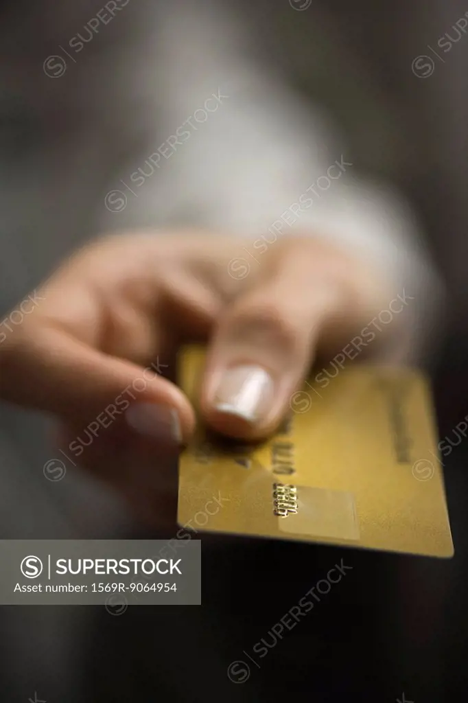 Woman´s hand holding out credit card, extreme close-up
