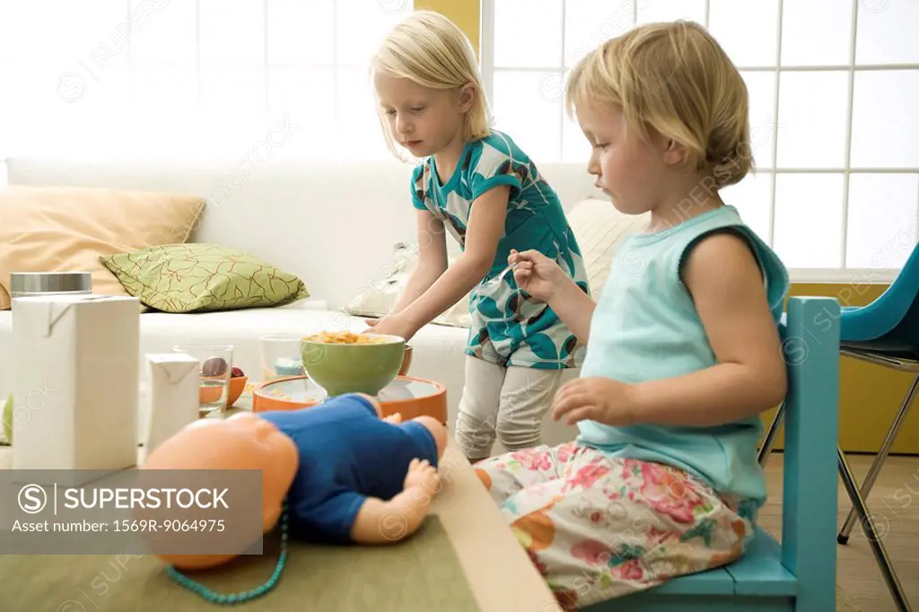 Little girls eating cereal at messy table