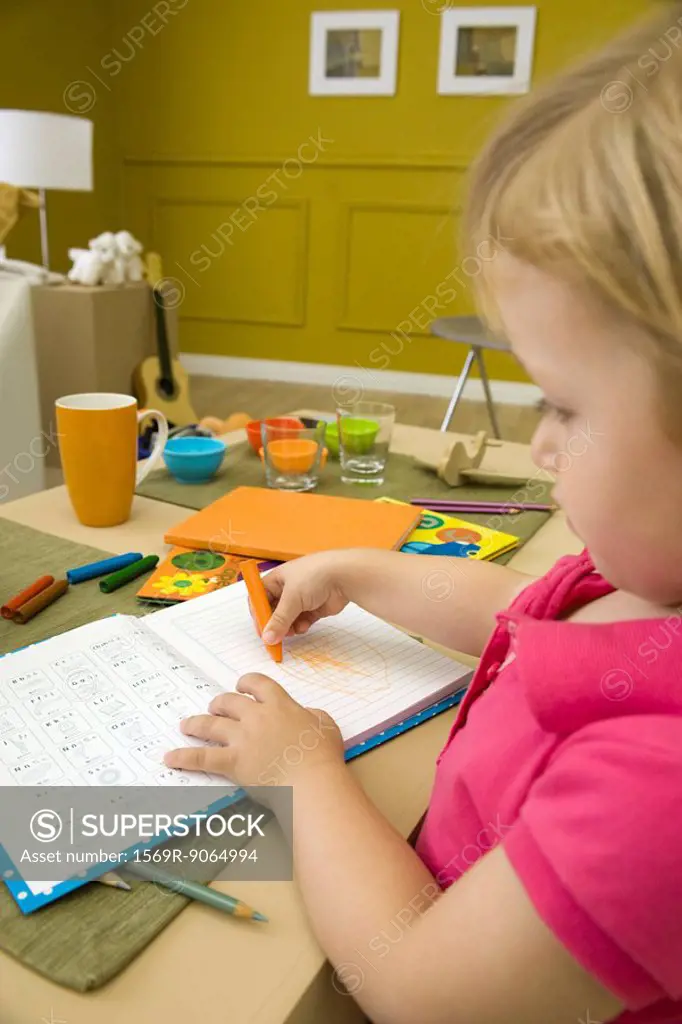 Little girl coloring at table, close-up