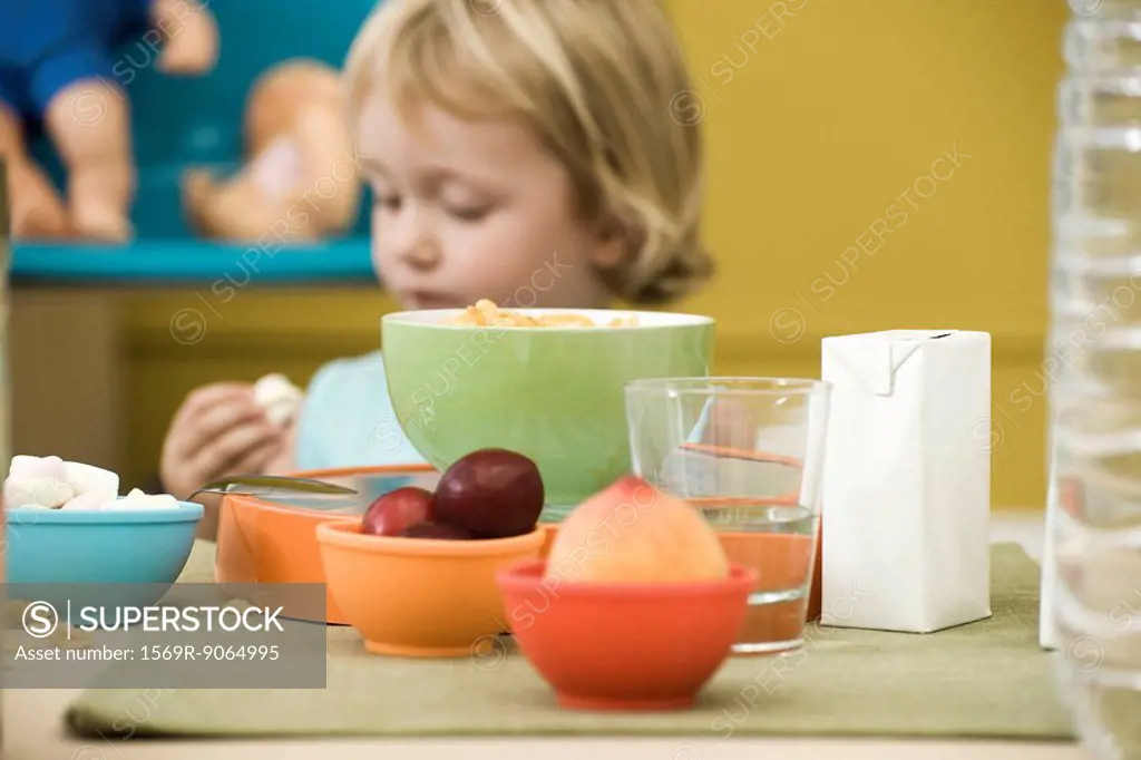 Little girl eating snack at messy table