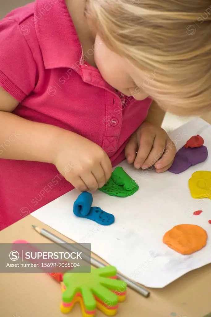 Little girl playing with clay