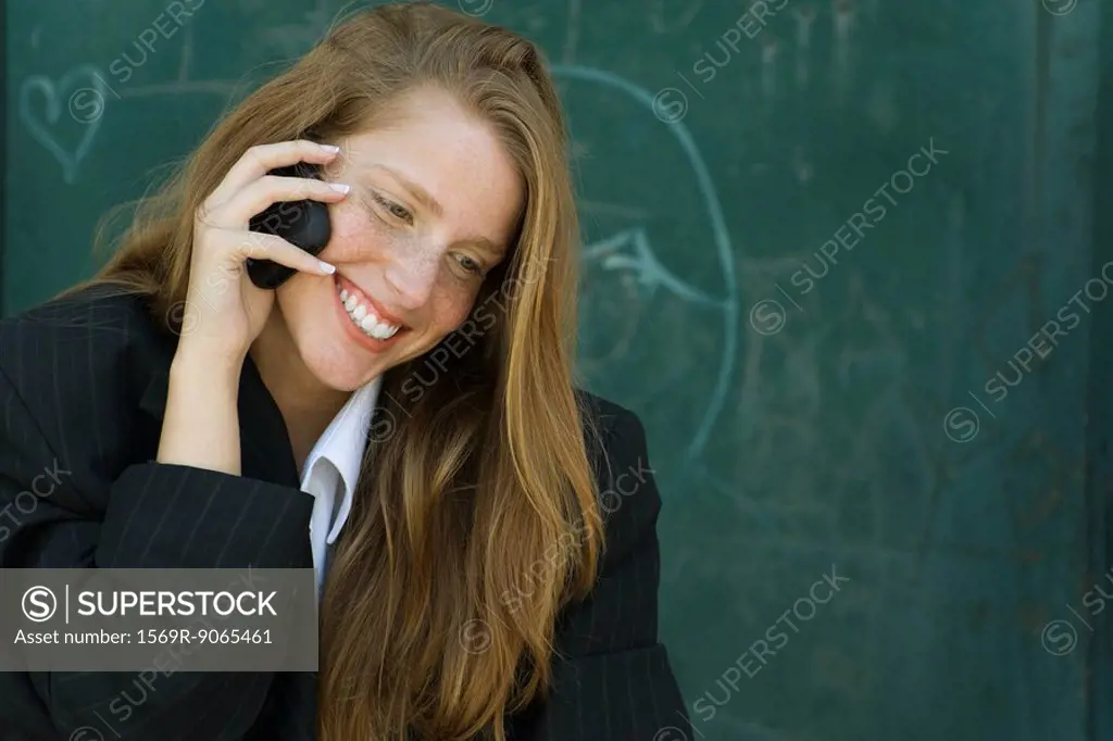 Young woman with strawberry blonde hair talking on cell phone