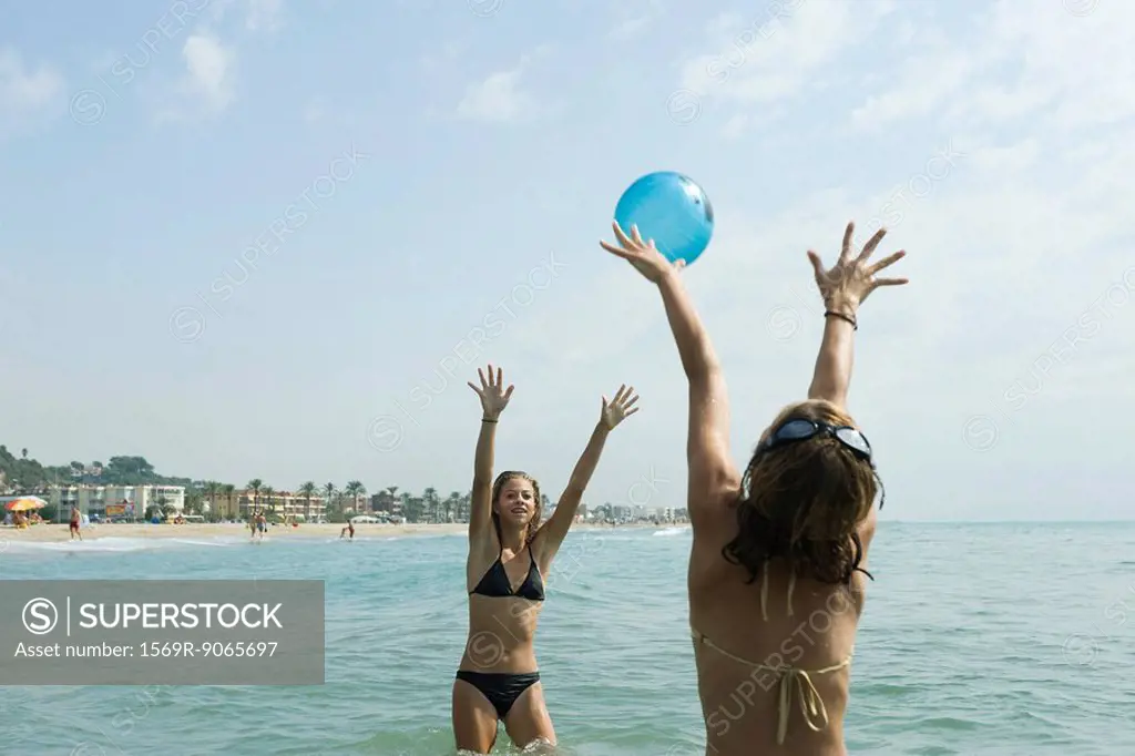 Teen girls playing with beach ball in sea