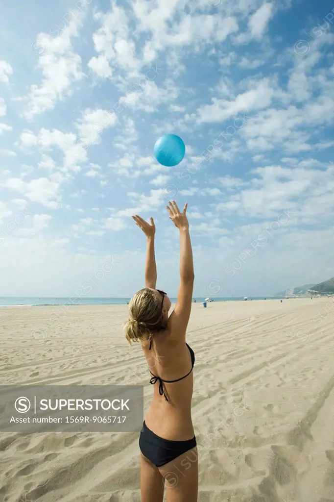 Teen girl playing beach volleyball