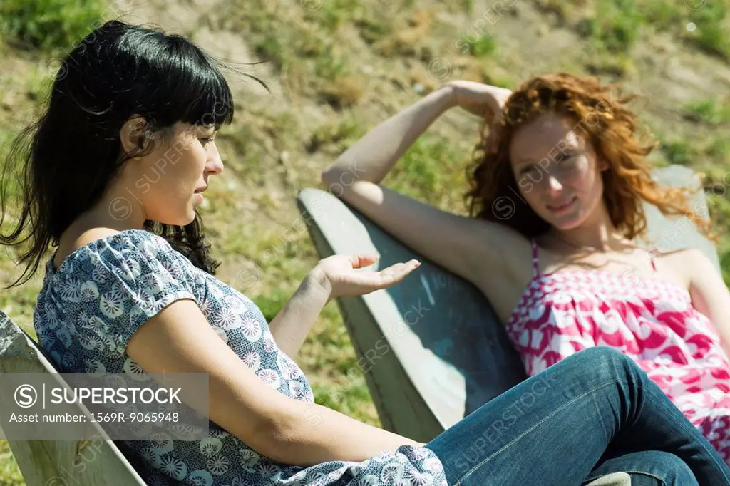 Two young women sitting outdoors, talking