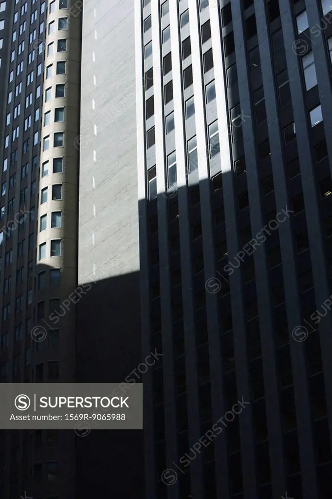 High rise office buildings side by side, partially obscurred by shadow, cropped