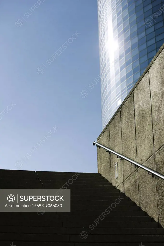 Stairs leading up from subway entrance, high risde building in background, low angle view