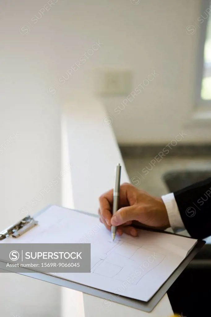 Person drawing on clipboard pad