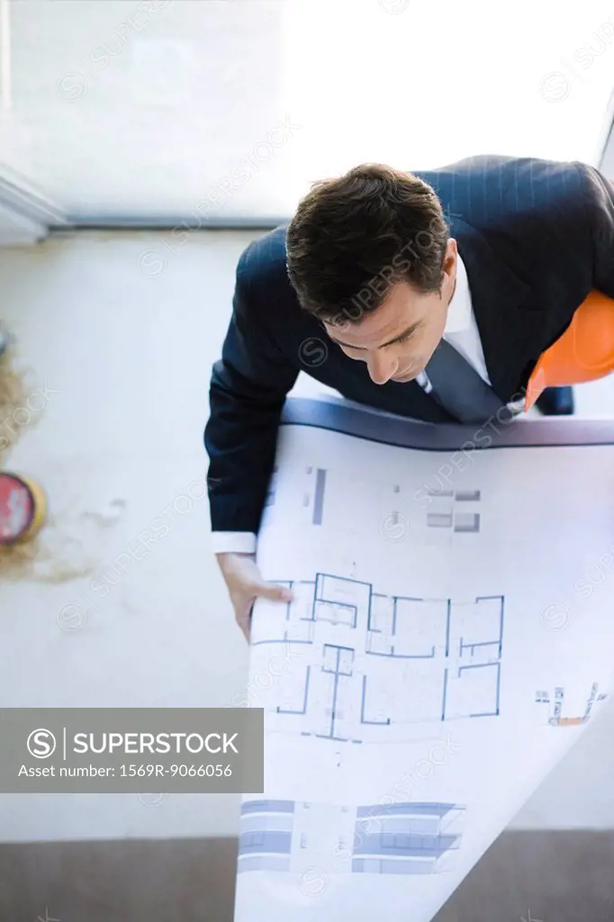 Man in suit reviewing blueprint
