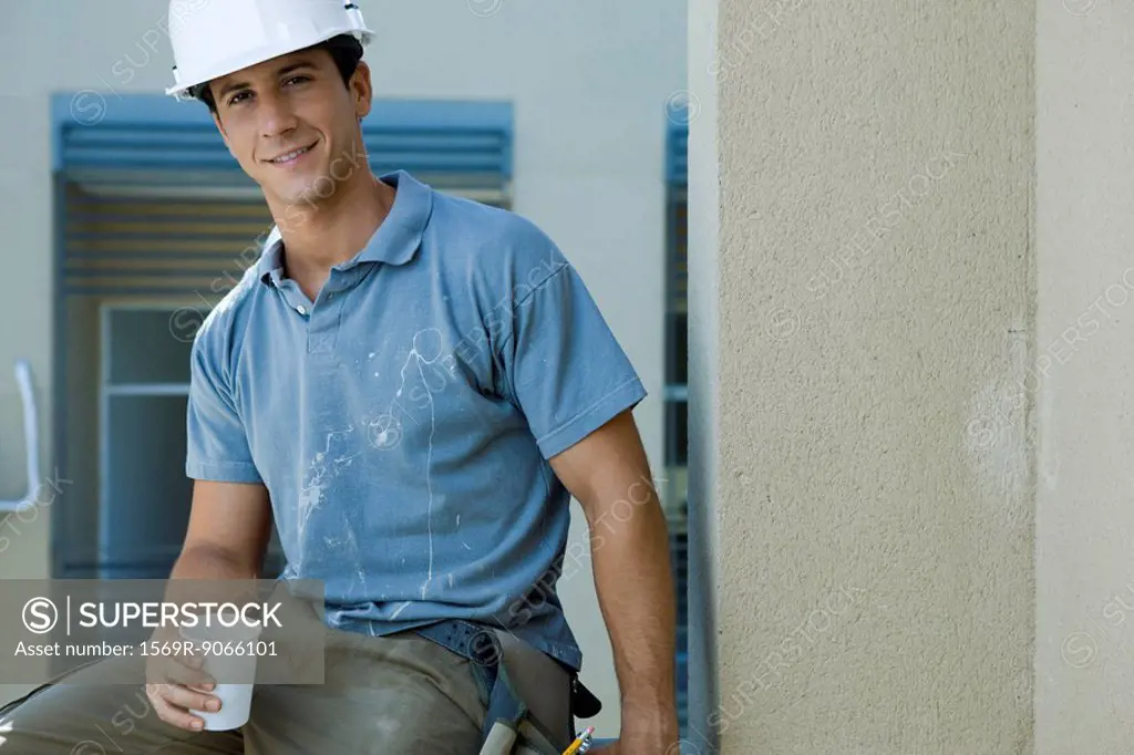 Construction worker holding disposable cup, taking break