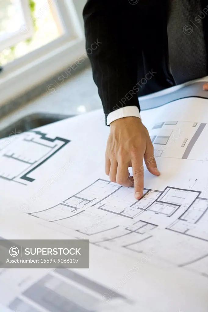 Man pointing at area on blueprint, close_up
