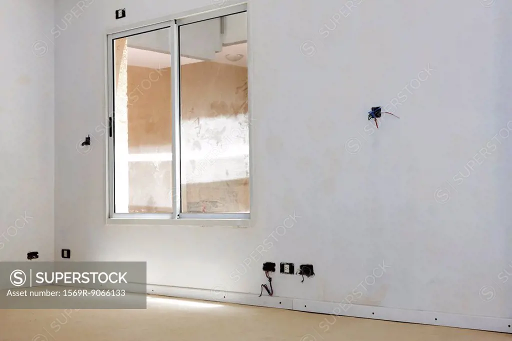 Interior of apartment under renovation, streaked windows, uninstalled electrical sockets