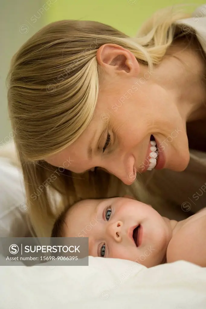 Mother leaning over baby, smiling