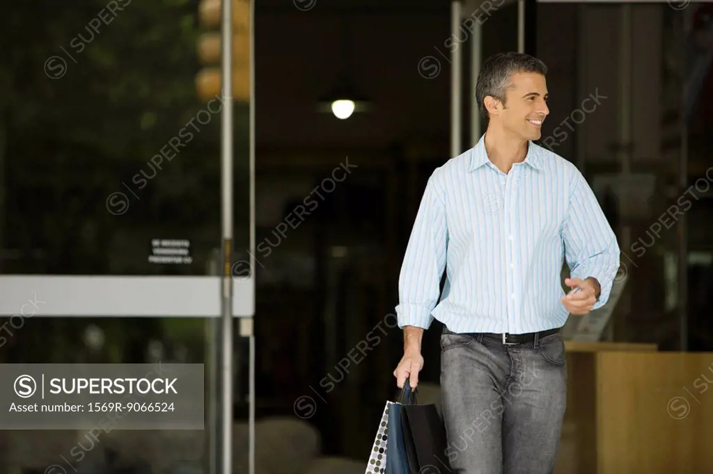 Man leaving store with shopping bags