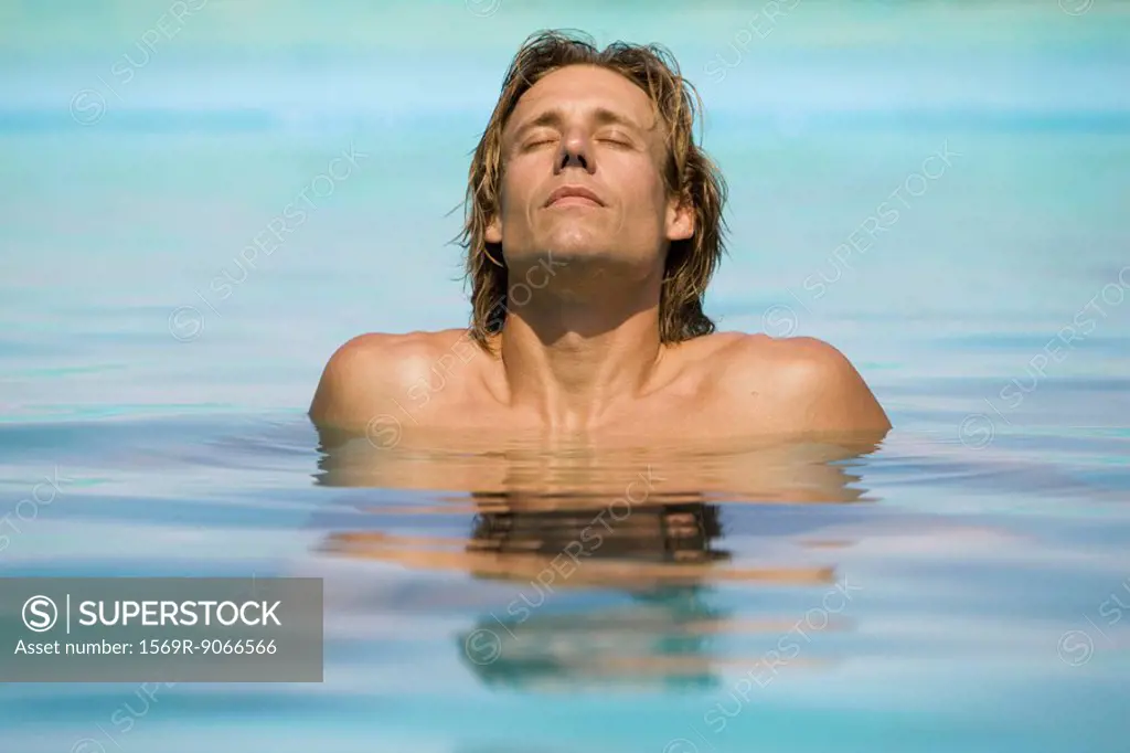 Man relaxing in shallow end of pool