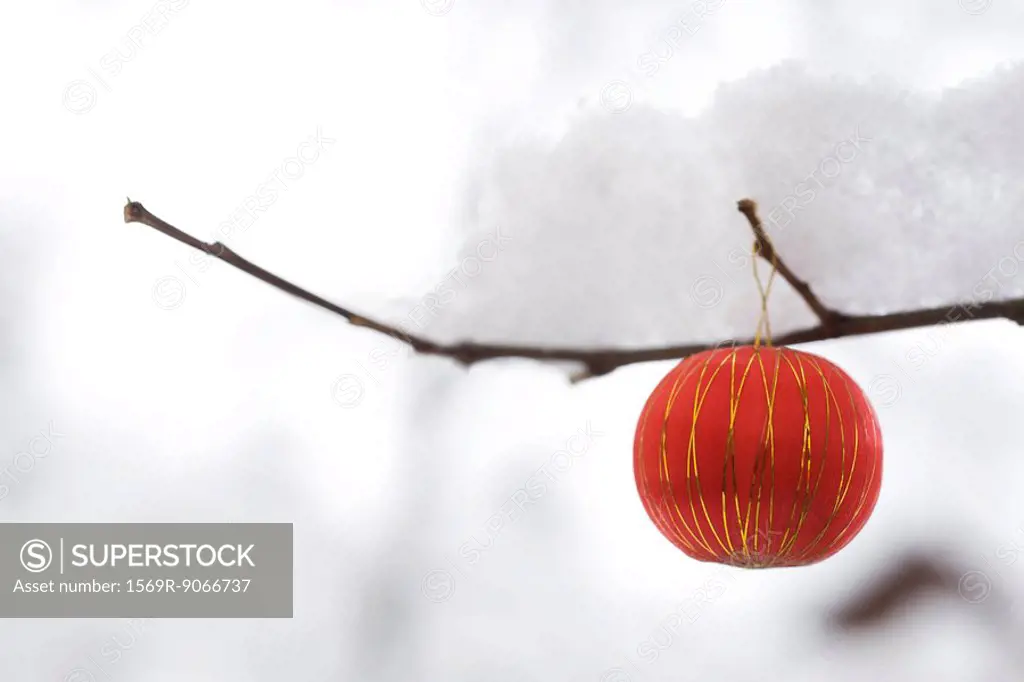 Christmas ornament hanging from snow_covered branch