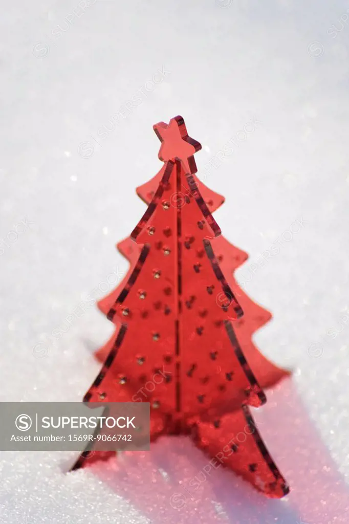 Red plastic Christmas tree decoration set in snow