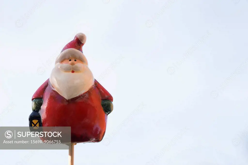 Santa Claus figurine on thin wooden post