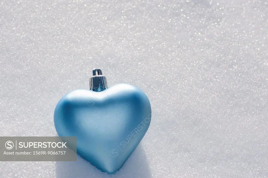 Heart shaped ornament lying on snow
