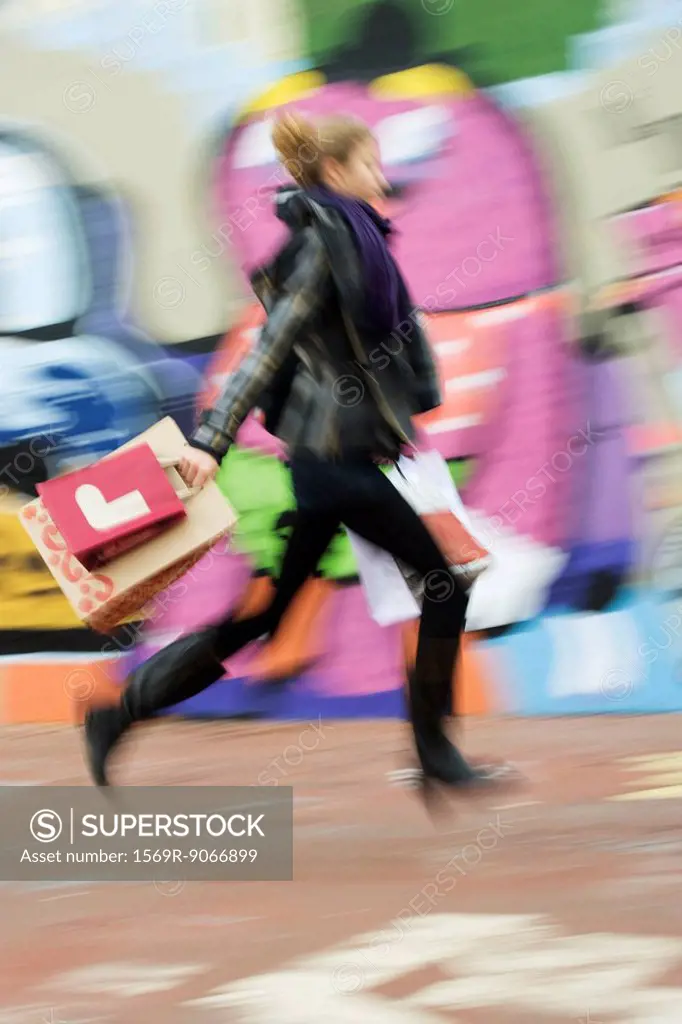 Teenage girl walking with shopping bags, blurred