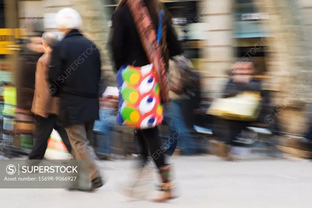 Pedestrians walking on sidewalk, blurred