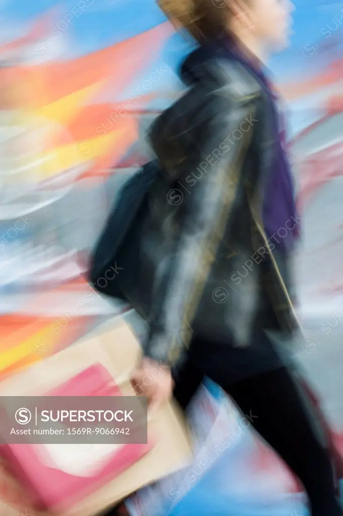 Shopper carrying shopping bags, blurred